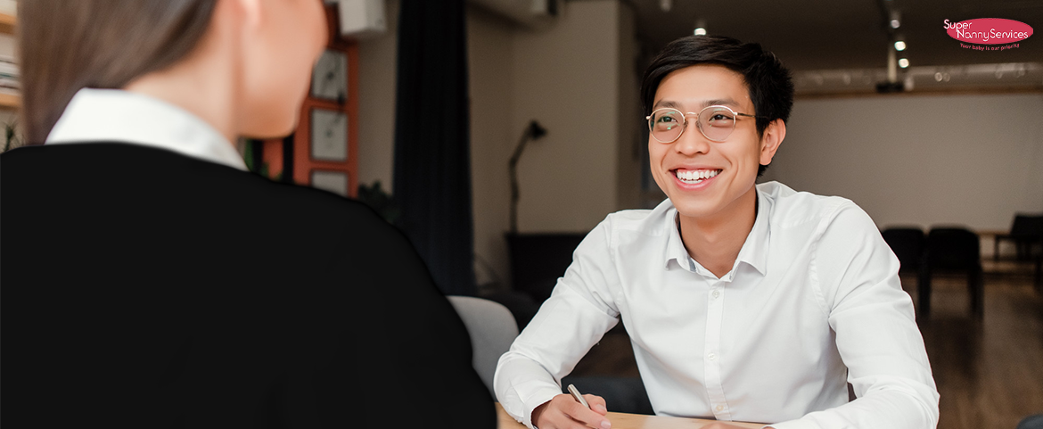 A person in glasses smiling at another person