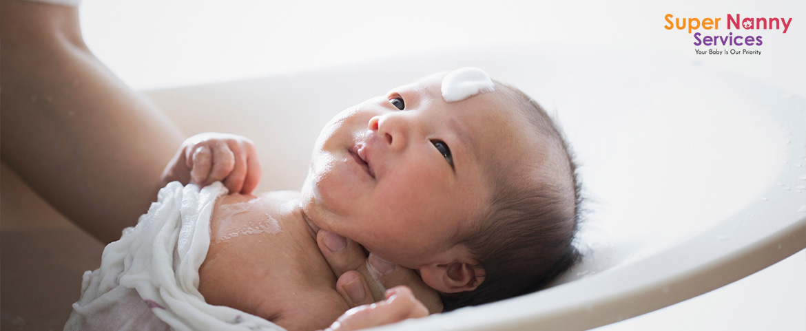 A Mother Bathing Her Baby With Baby Bathtub