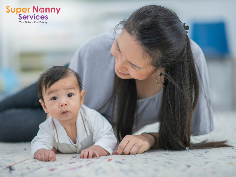 Image of mother playing with her infant on the floor