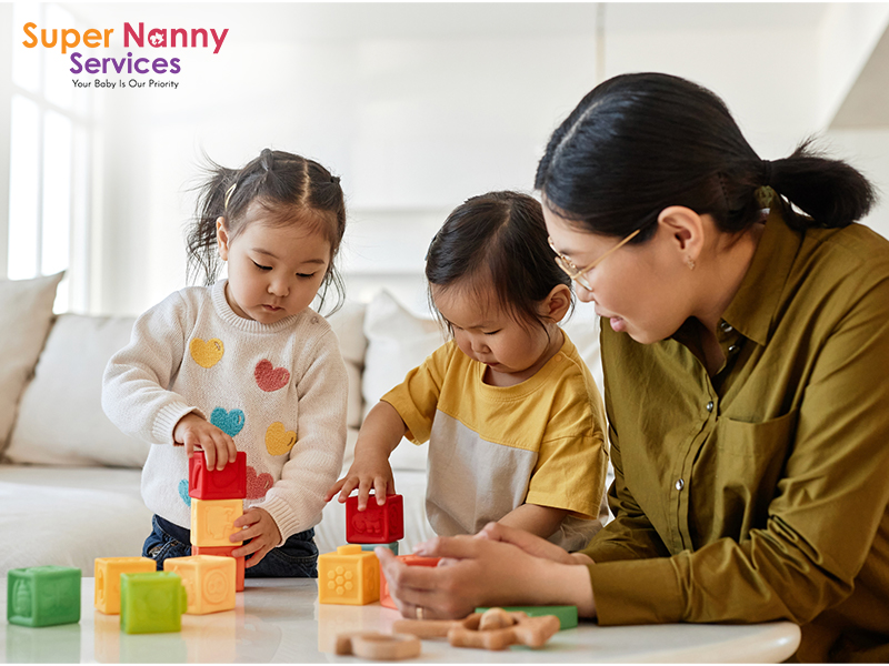 Image of a Nanny playing with child siblings