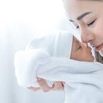 Mother touching nose with her baby