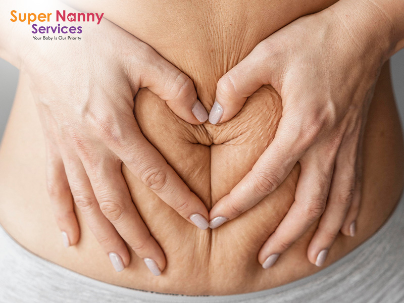 A mother making a heart shape on her postpartum abdomen.