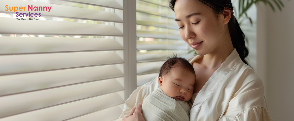 New mother lovingly holding her sleeping newborn baby near window.