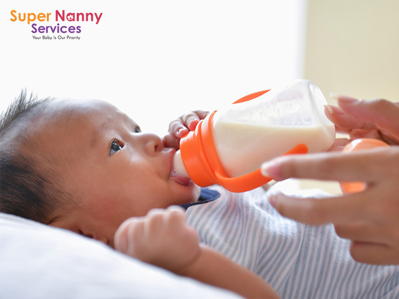 Baby being bottle-fed by his mother.